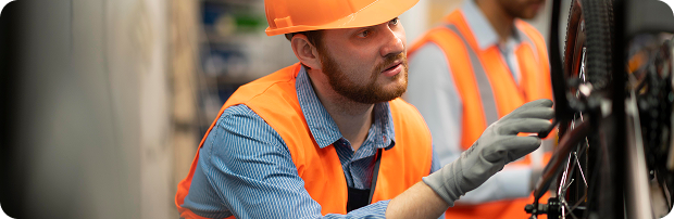 Industrial technician inspecting electrical cable installation in a manufacturing environment